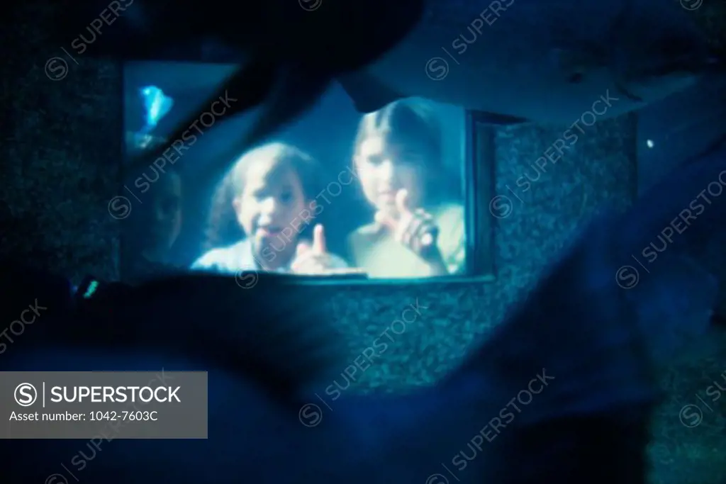 View of children looking through an aquarium window