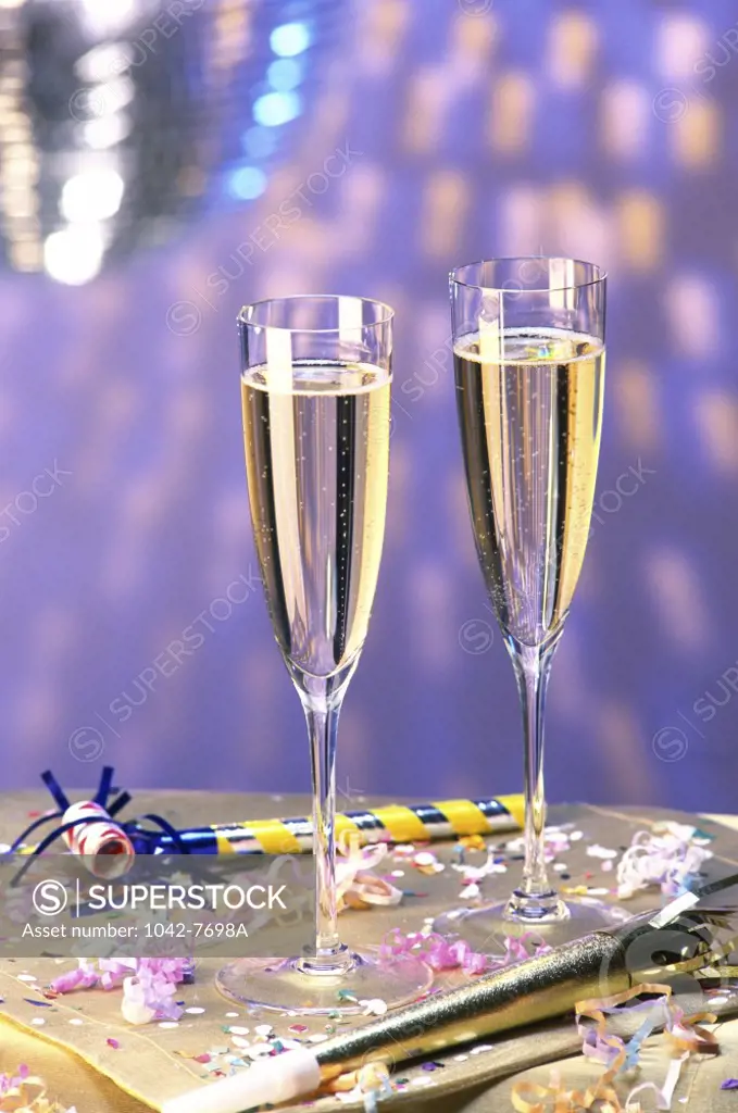 Two champagne glasses and party horn blowers