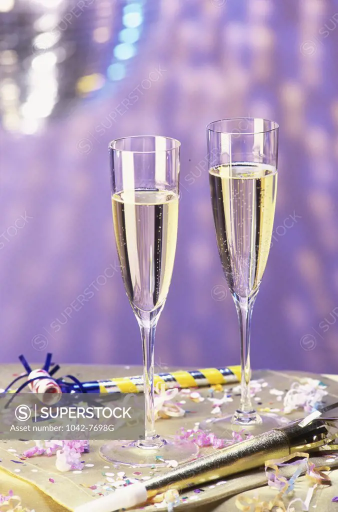 Two champagne glasses and party horn blowers