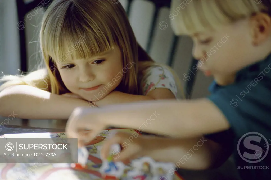Close-up of a girl and a boy playing a board game