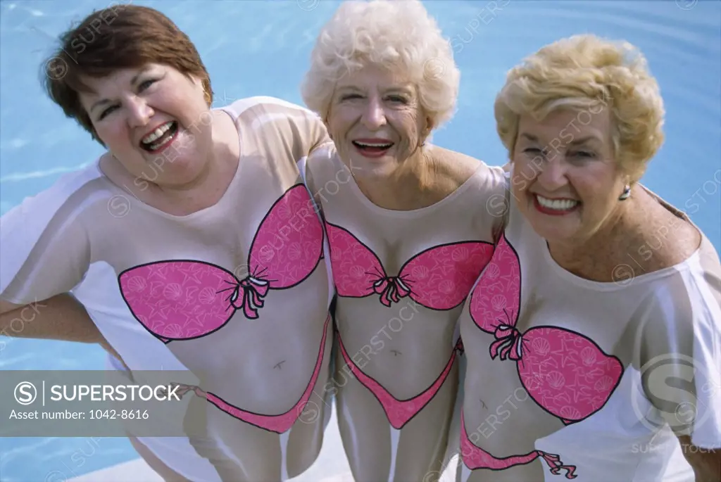 Portrait of three senior women standing beside a swimming pool