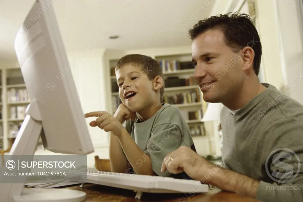 Side profile of a father and his son using a computer