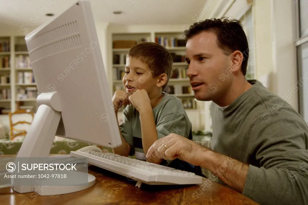 Young man and his son using a computer