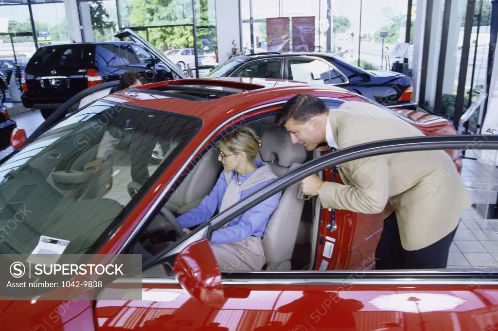 Mid adult couple looking at a car in a showroom