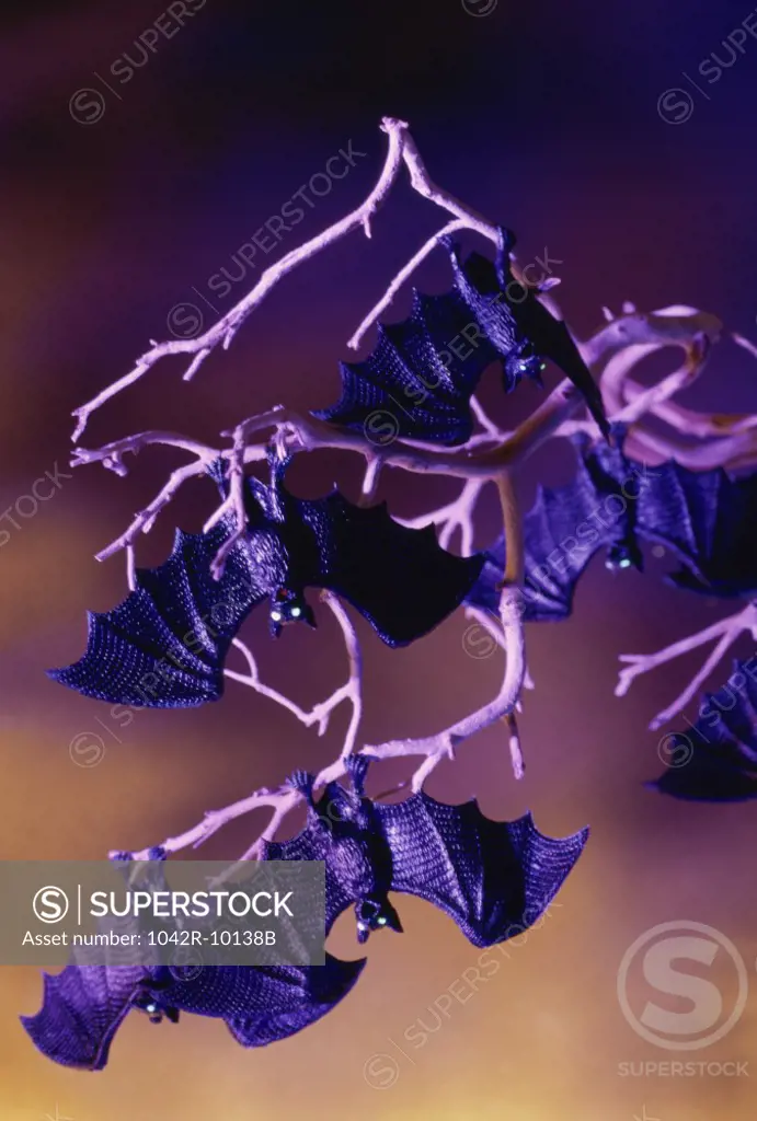 Plastic bats hanging on branches of a tree