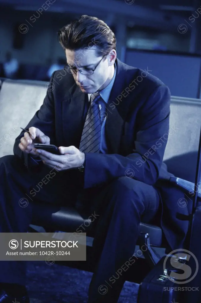Businessman sitting operating a hand held device