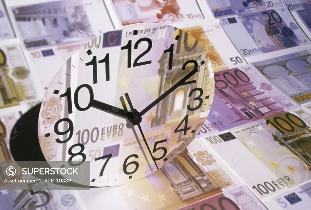 Euro banknotes with a clock in the foreground
