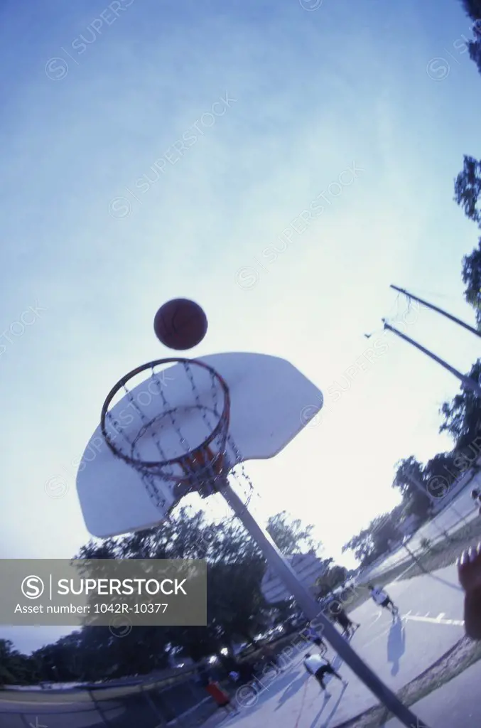 Low angle view of a basketball above a hoop