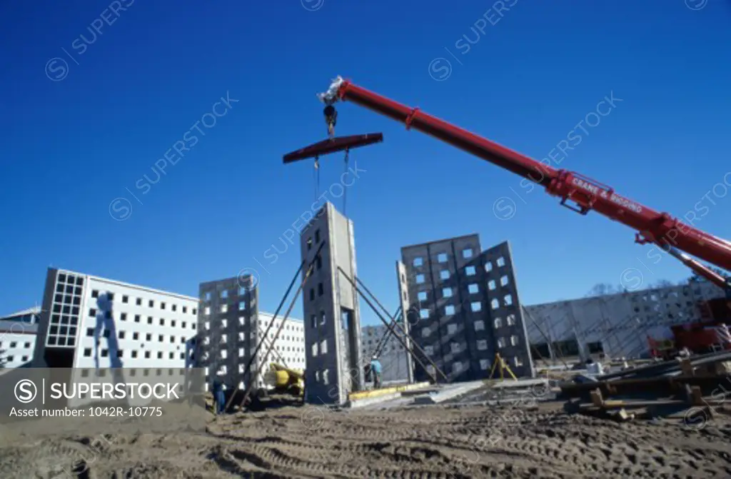 Low angle view of a crane carrying a section of a building