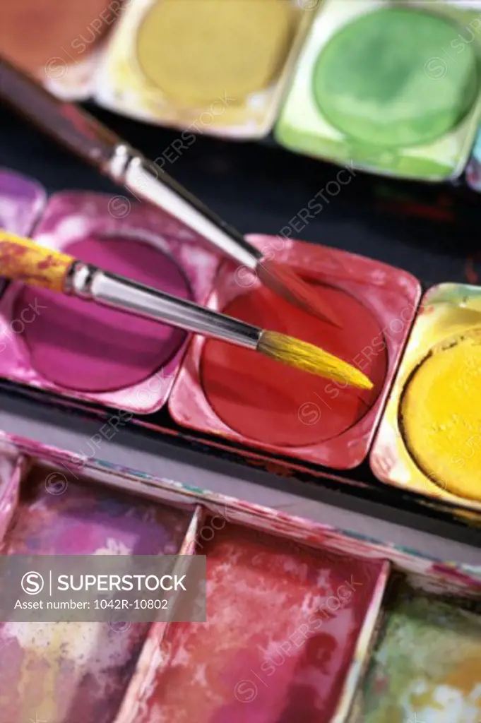 Close-up of paintbrushes over a color palette