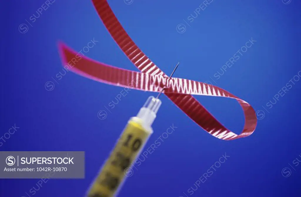 Close-up of a syringe with an AIDS awareness ribbon