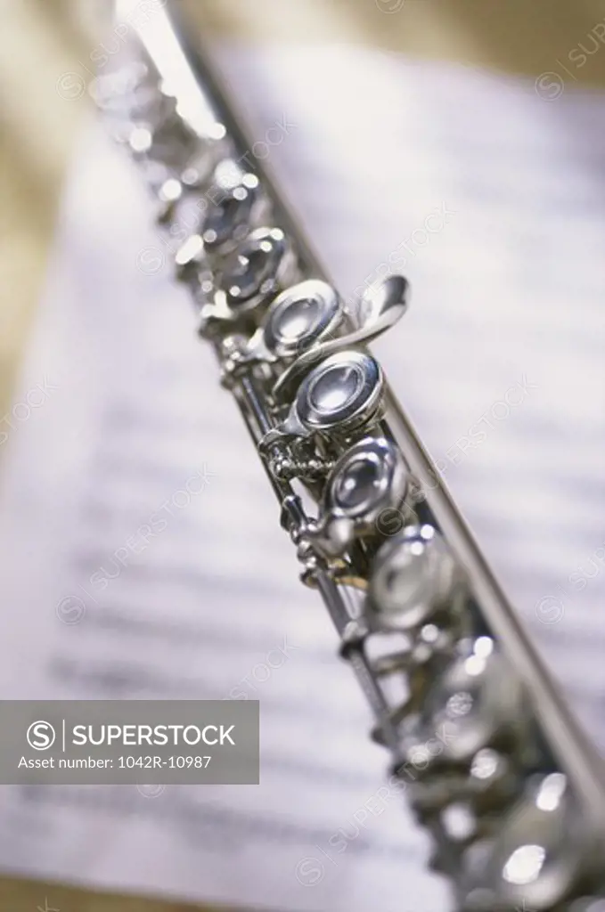Close-up of a flute on music sheets