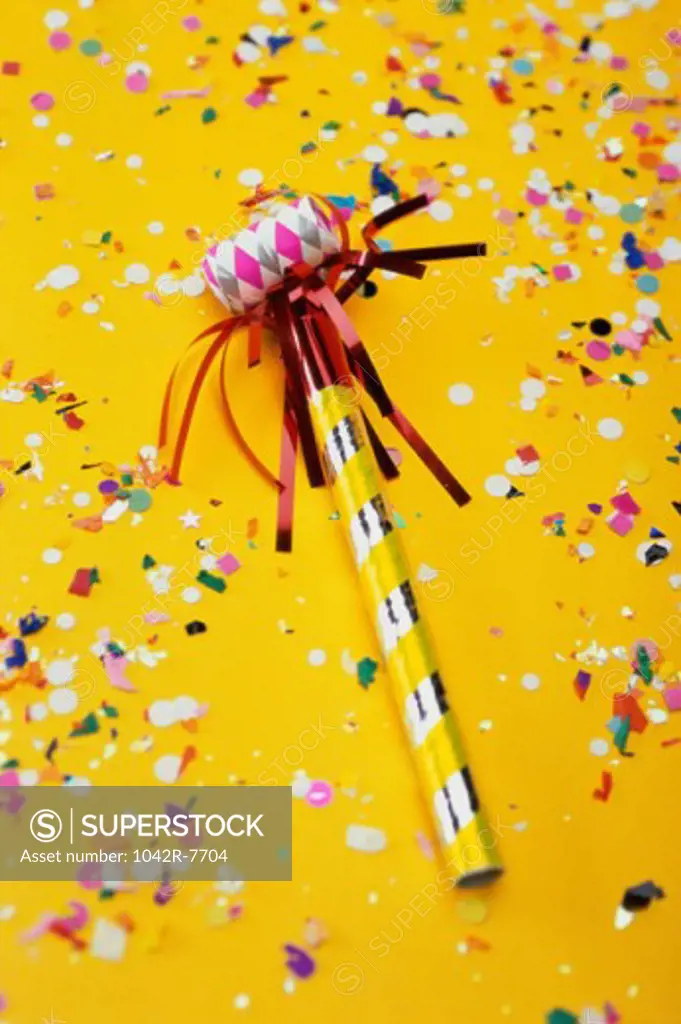 Close-up of a party horn blower and confetti