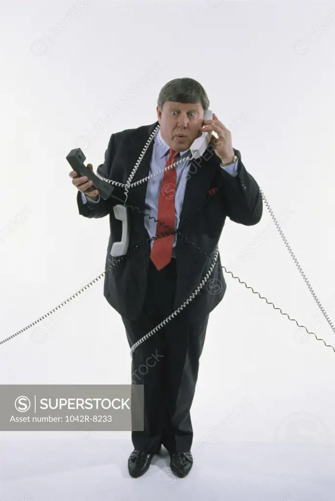 Businessman holding landline telephone receivers