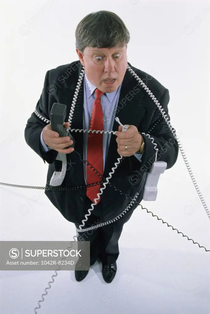 Businessman holding landline telephone receivers