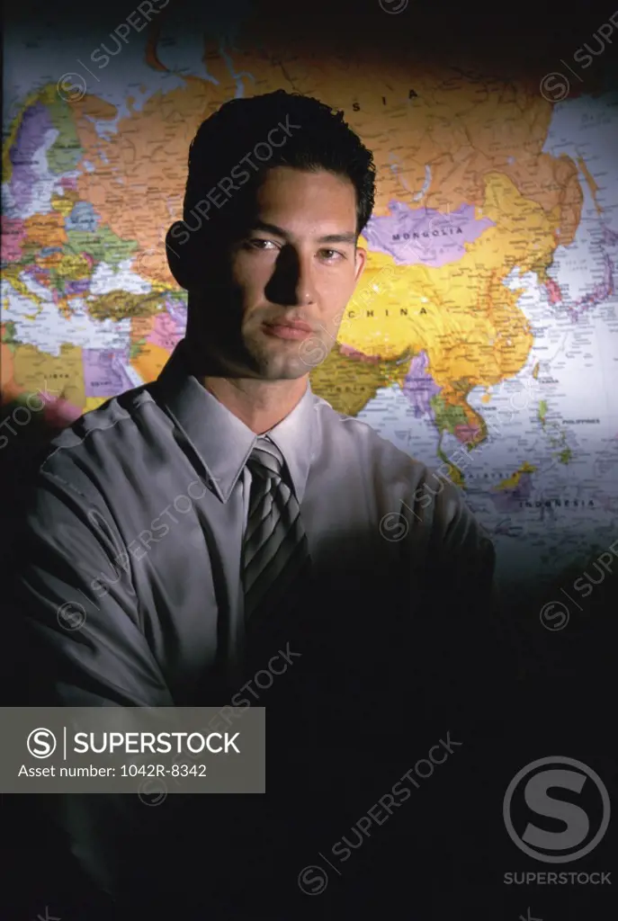 Portrait of a businessman standing in front of a map