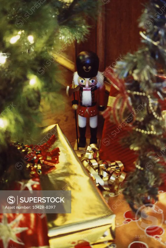 Nutcracker soldier with a Christmas tree and gifts