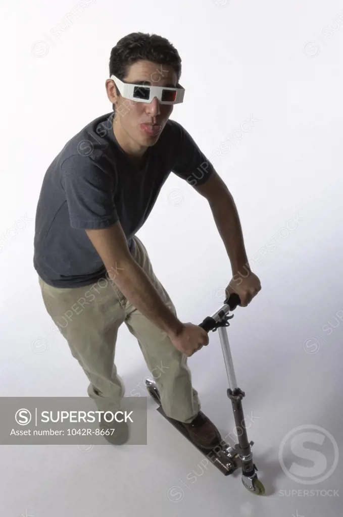 Teenage boy riding on a push scooter
