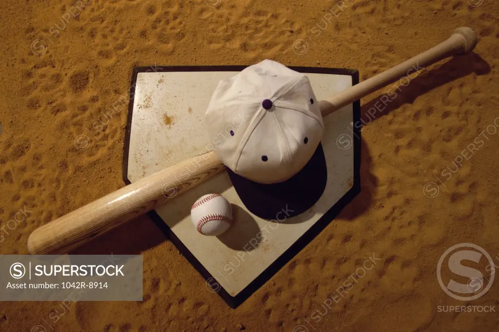 Baseball bat with a cap and a baseball on the home base