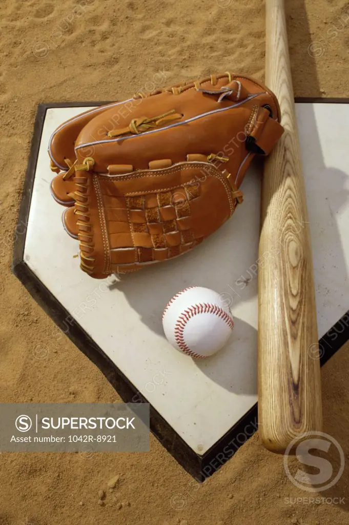 Baseball bat with a glove and a baseball on the home base
