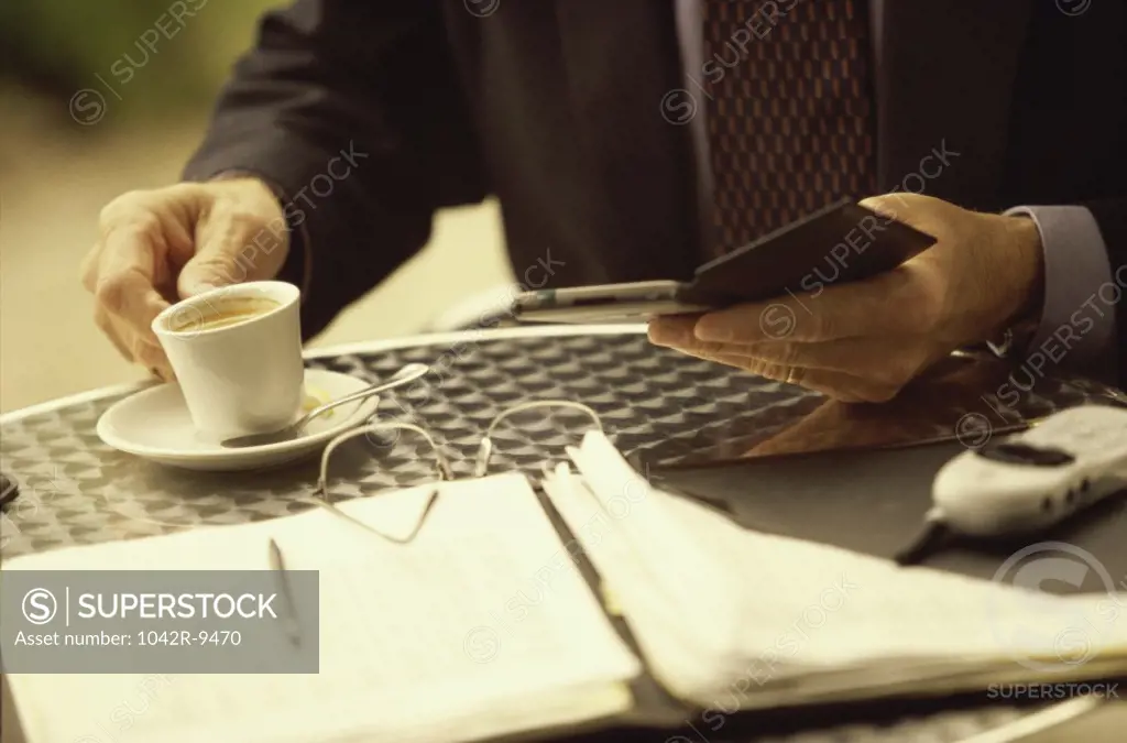 Businessman holding a wallet and a cup of coffee