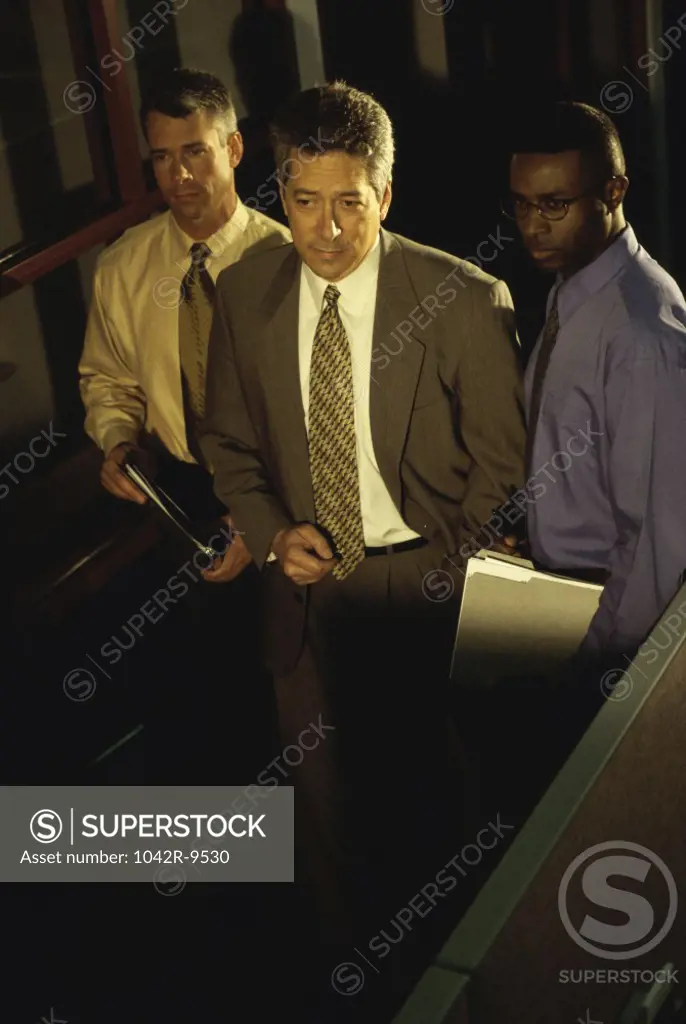 High angle view of three businessmen walking in a corridor