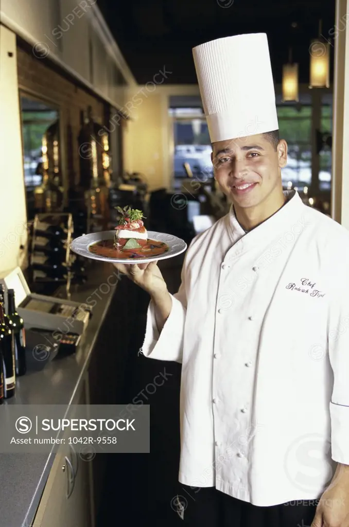 Portrait of a chef holding a plate of food