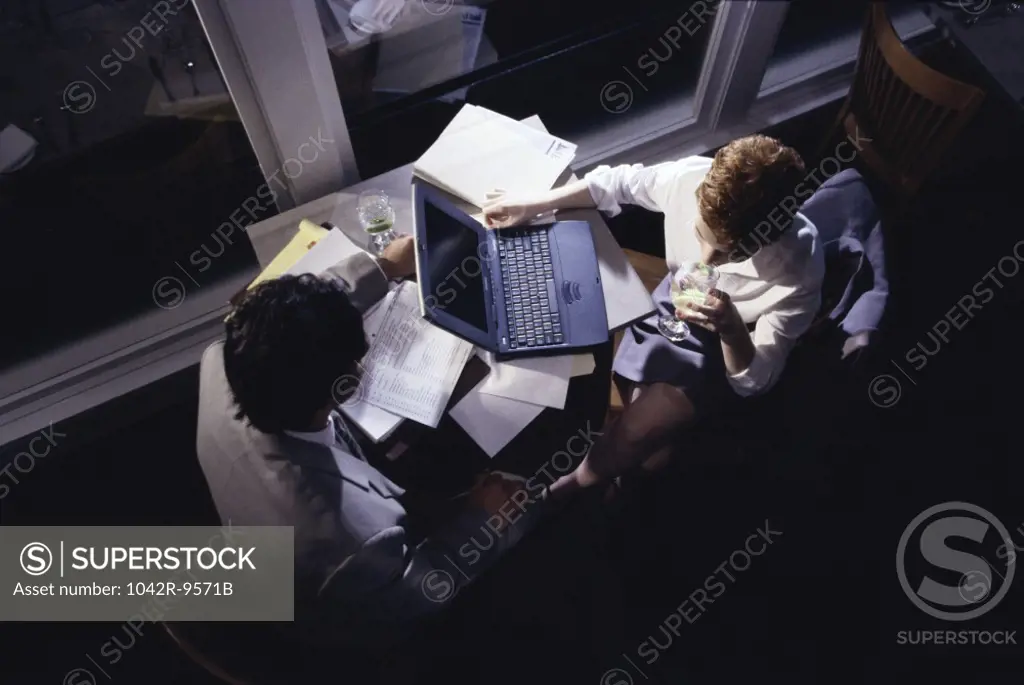 High angle view of a businessman and a businesswoman working on a laptop