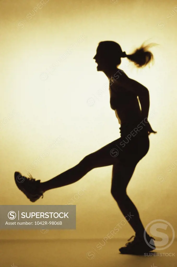Silhouette of a young woman exercising