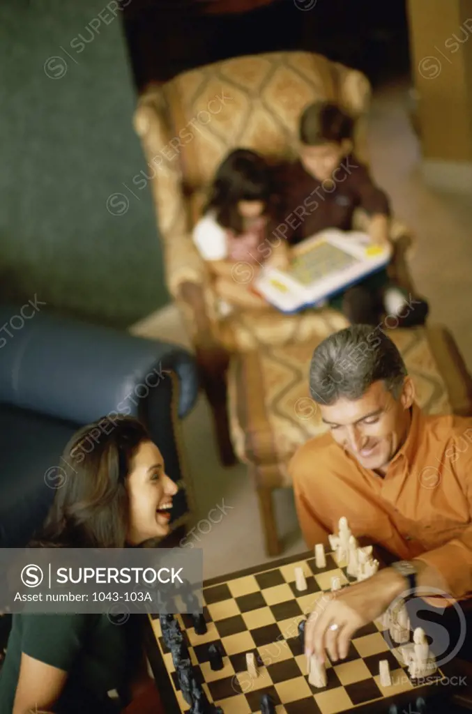 High angle view of parents playing chess