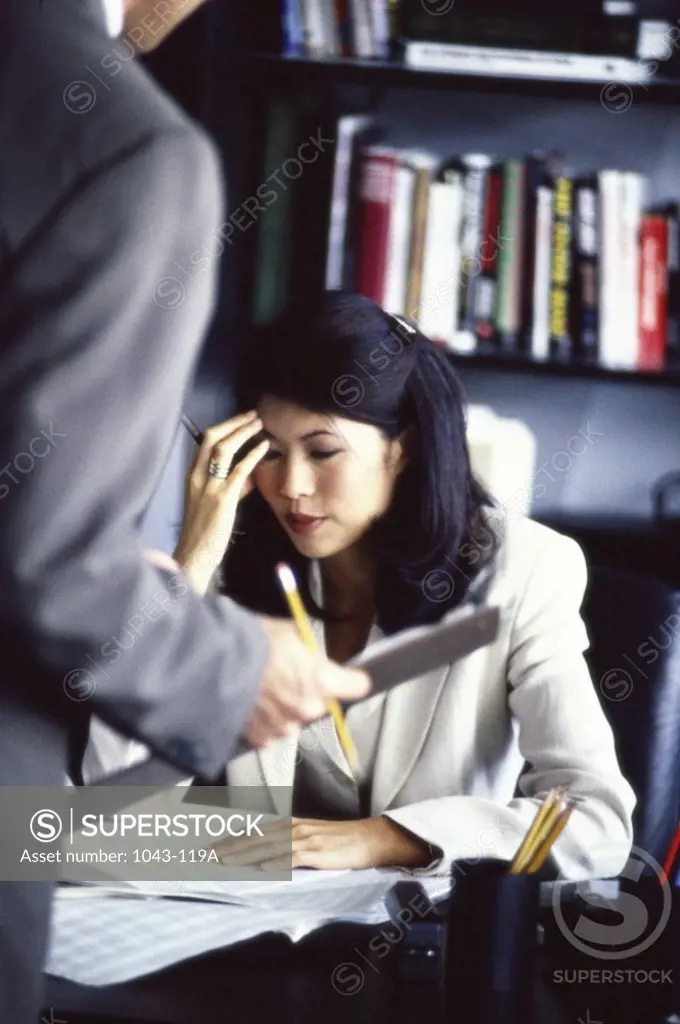 Businesswoman sitting with her hand on her head