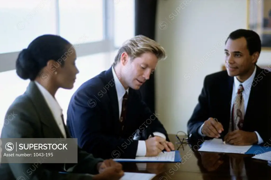 Two businessmen and a businesswoman in a meeting