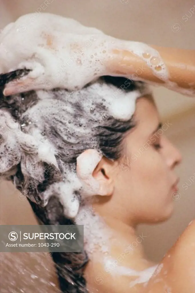 Close-up of a young woman shampooing her hair