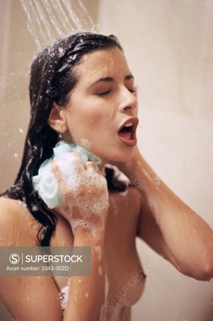 Young woman using a loofah scrub in the shower