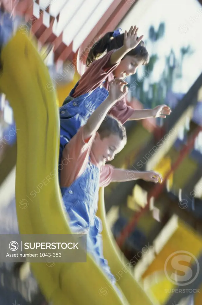 Boy and girl playing on a slide