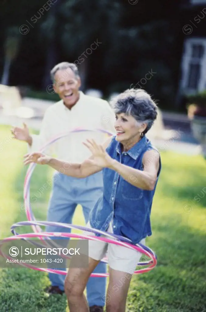 Senior couple playing with hula hoops
