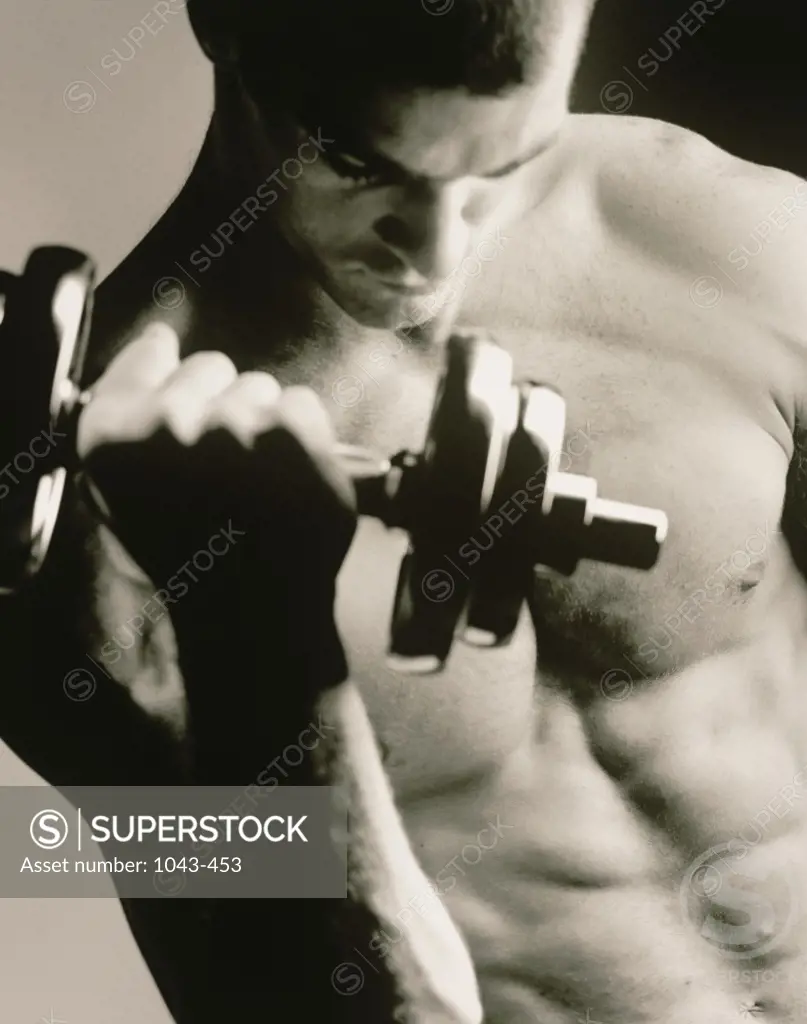 Close-up of a young man working out with a dumbbell