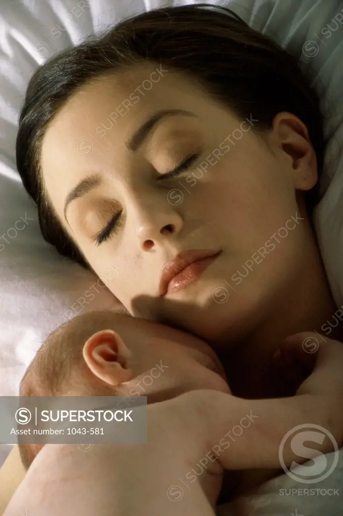 Mother sleeping with her baby boy