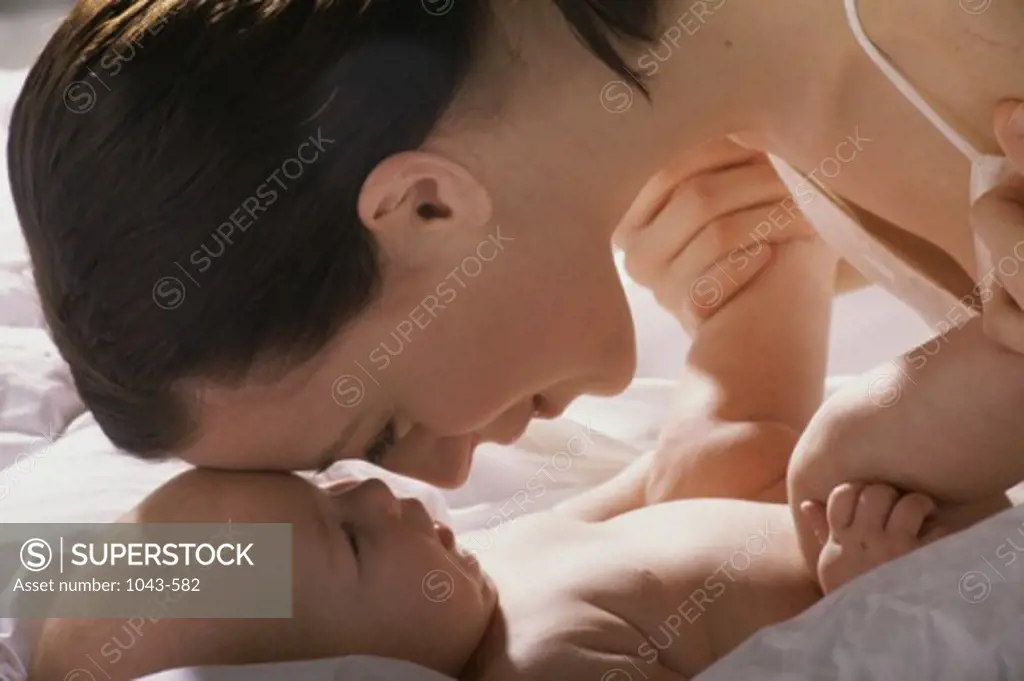 Side profile of a mother nuzzling her baby boy