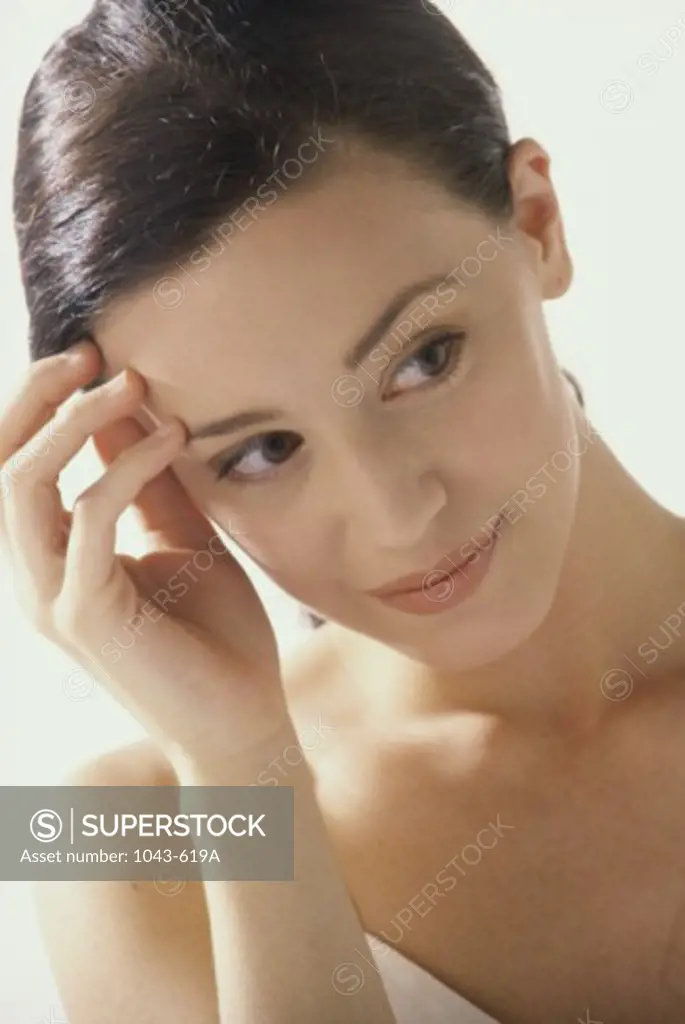 Close-up of a young woman with her hand on her forehead
