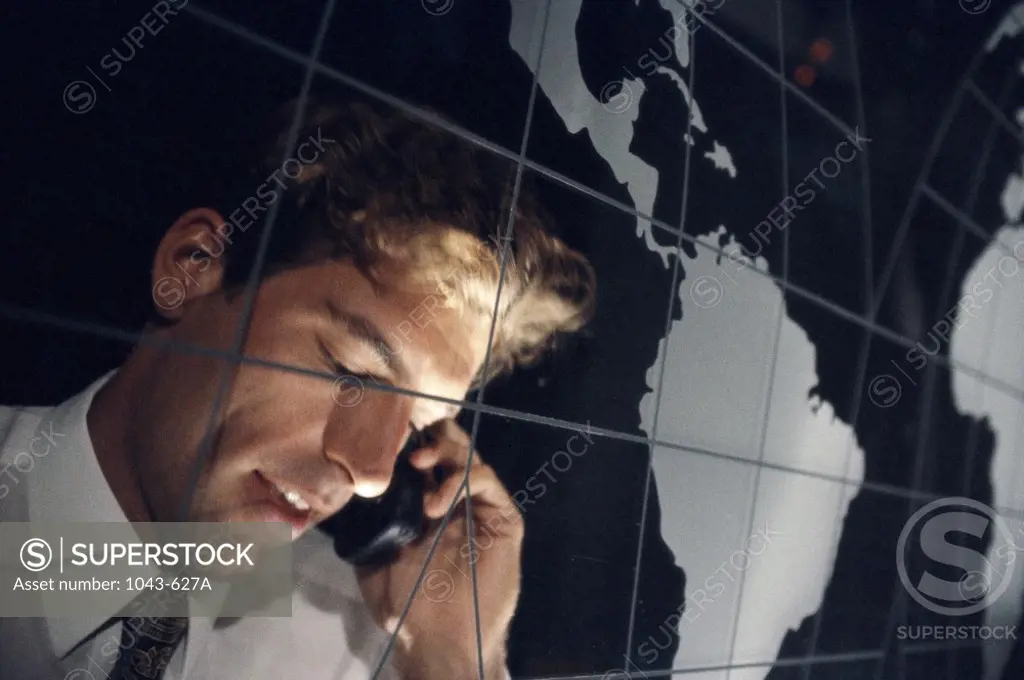 Close-up of a businessman standing in front of a world map