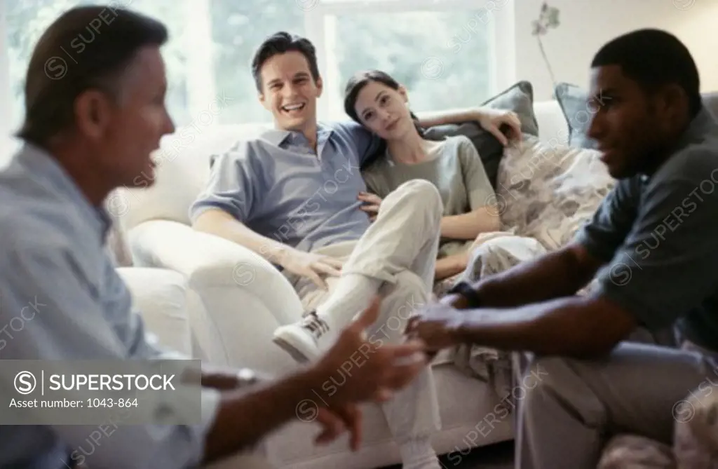 Mid adult couple sitting with two mid adult men