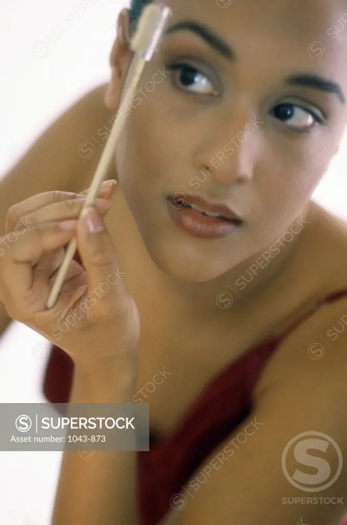 Young woman brushing her eyebrows