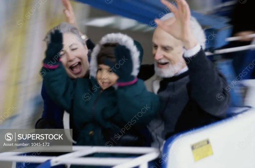 Granddaughter with her grandparents riding a roller coaster