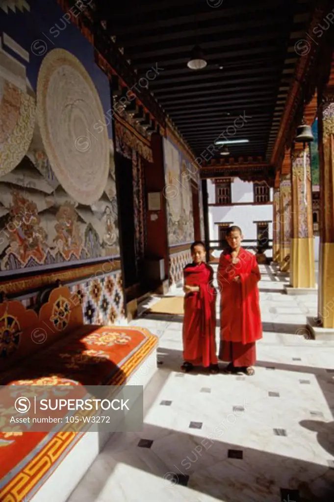 Two monks standing in a corridor of a temple, Trashi Chhoe Dzong, Thimphu, Bhutan
