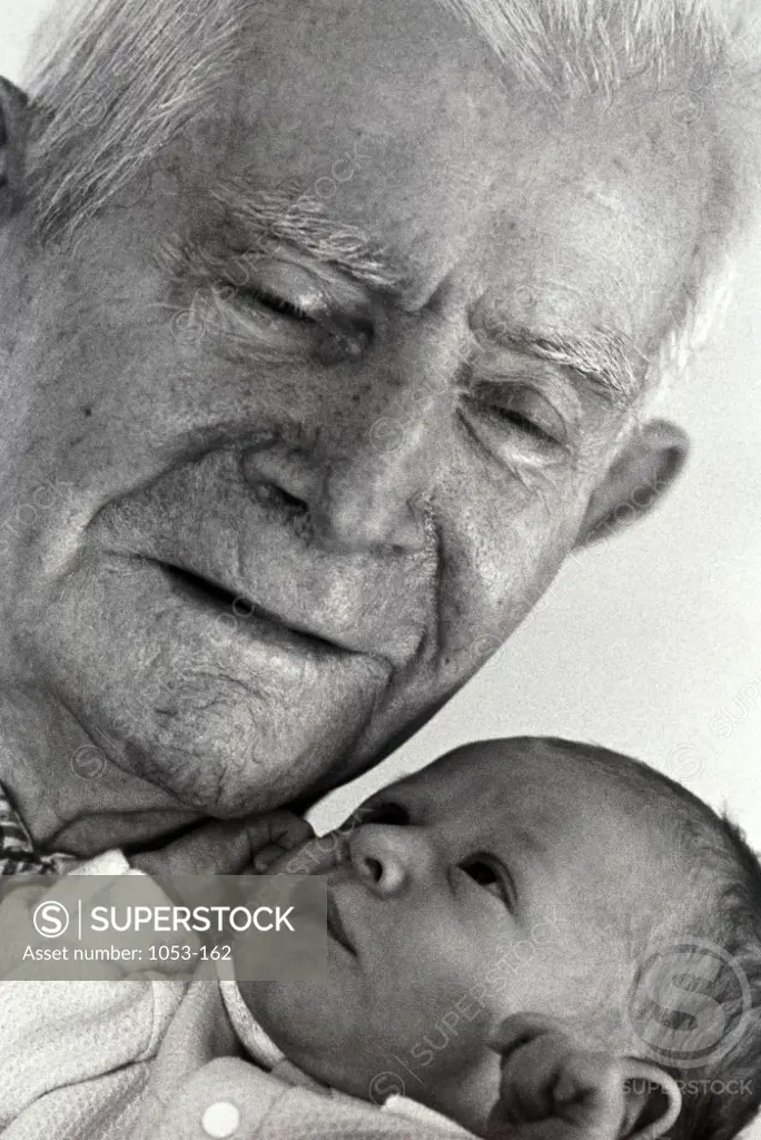 Close-up of senior man holding a baby
