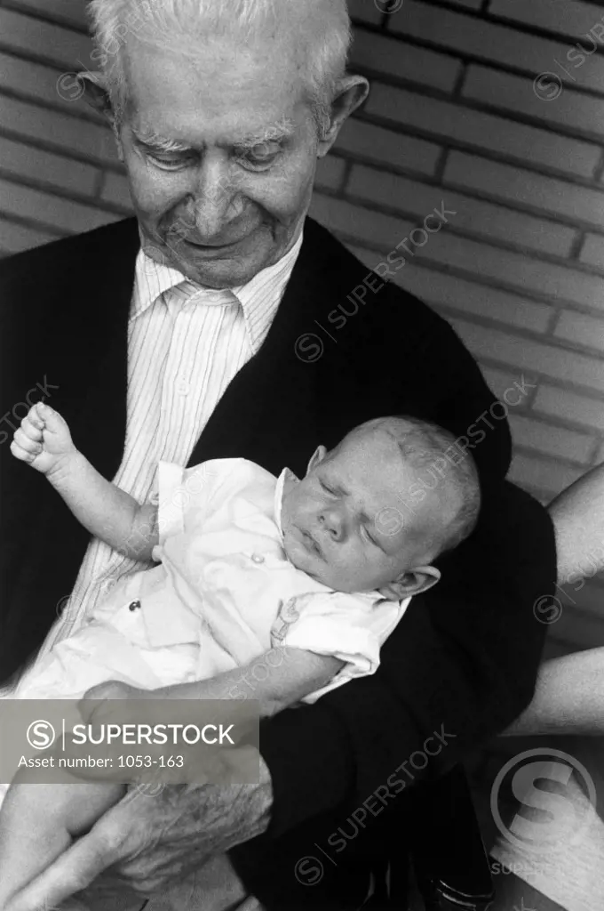 Portrait of senior man holding a baby
