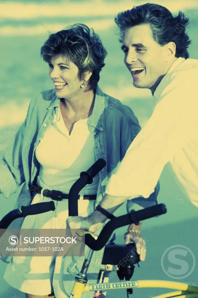 Mid adult couple holding bicycles on the beach