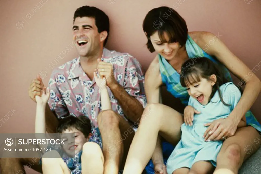 Mid adult couple playing with their son and daughter