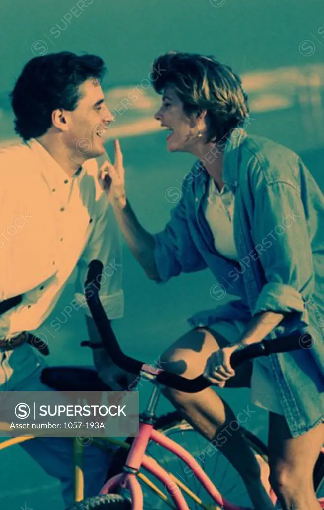 Mid adult couple with bicycles on the beach